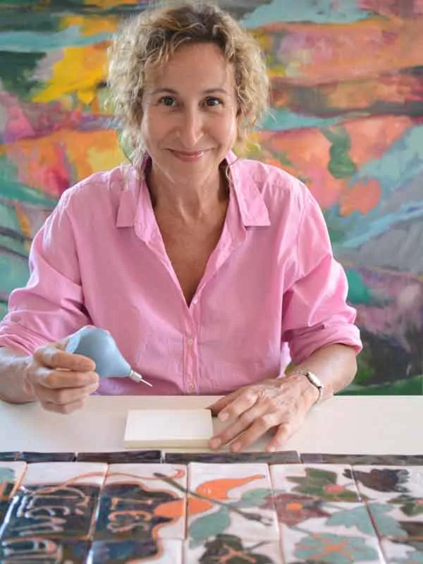 Peinture à la pipette d'un carreau de céramique dans l'atelier